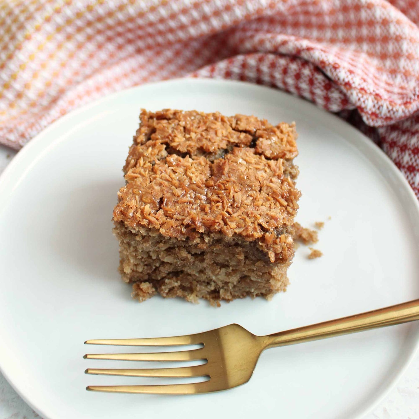 Image of Jamaican coconut cake recipe cake on a white plate with a gold fork