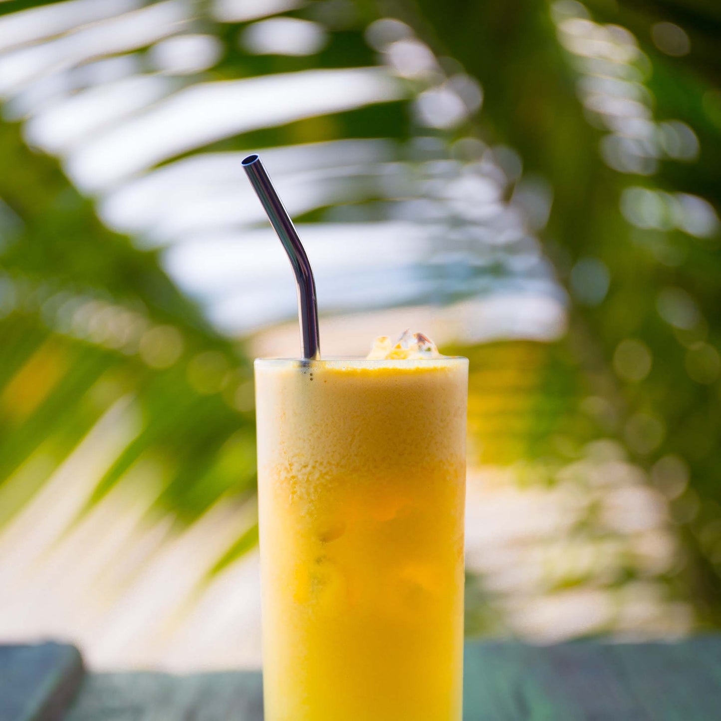 Image of a Caribbean rum cocktail with palm leaves in the background