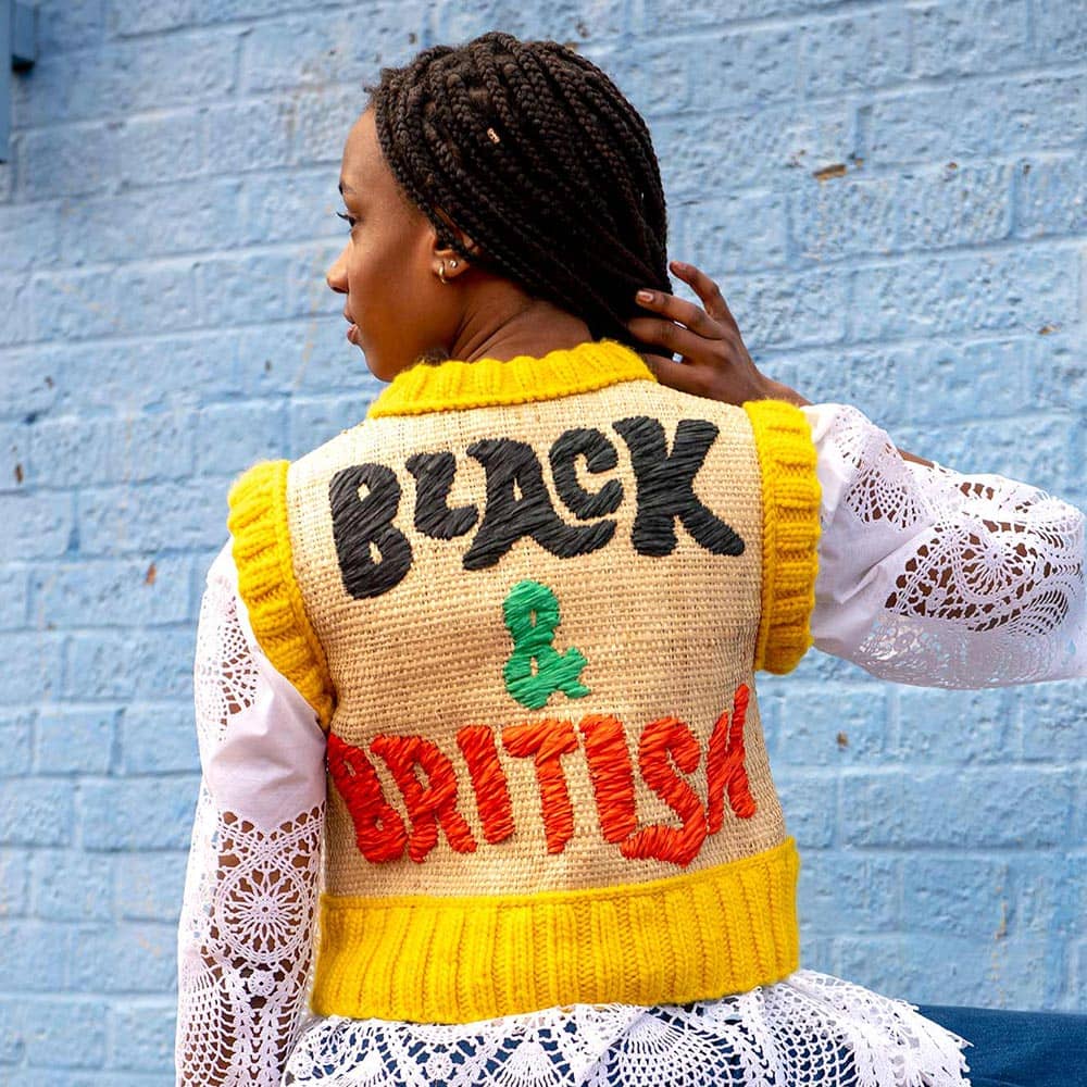 Image of the back view of model wearing 'Black & British' raffia embroidered vest